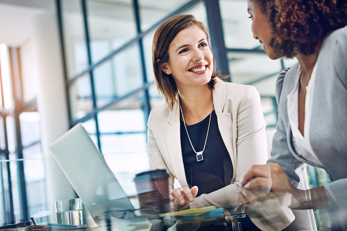 Shot of two young businesswomen using a laptop together at work