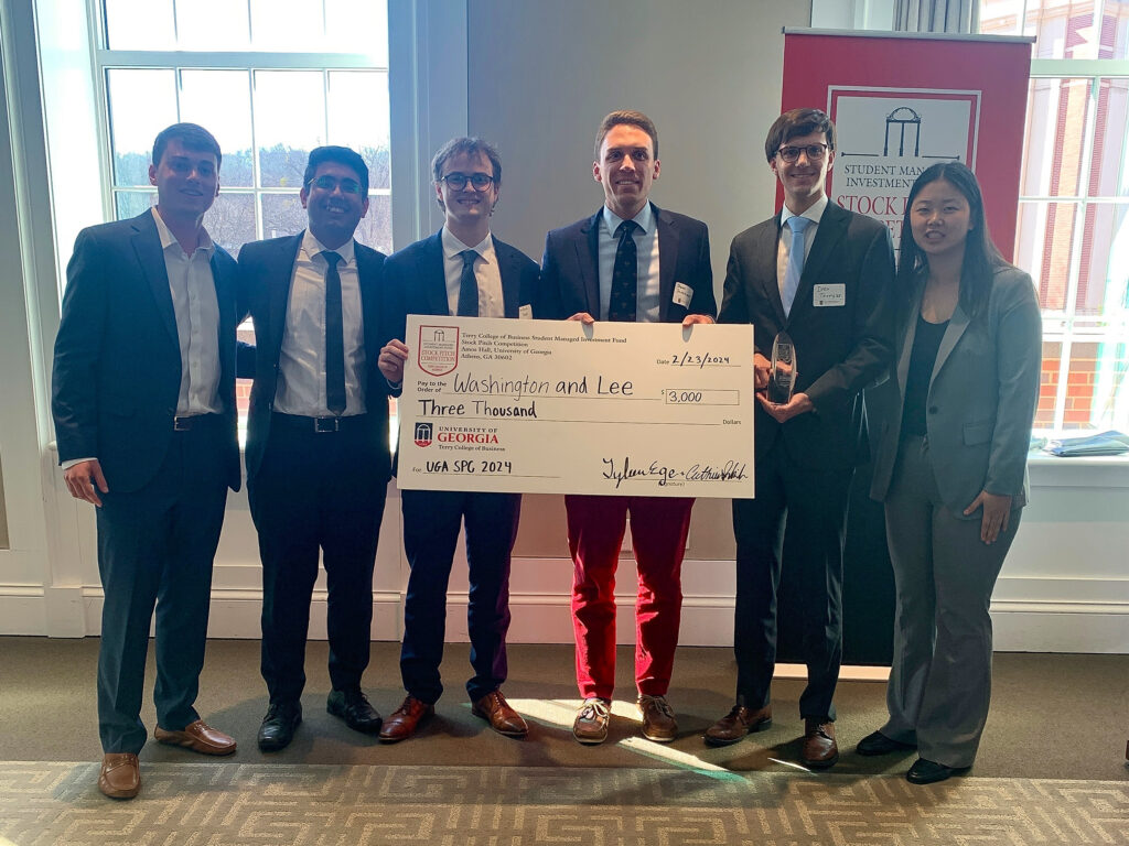 Group of people posing with a check