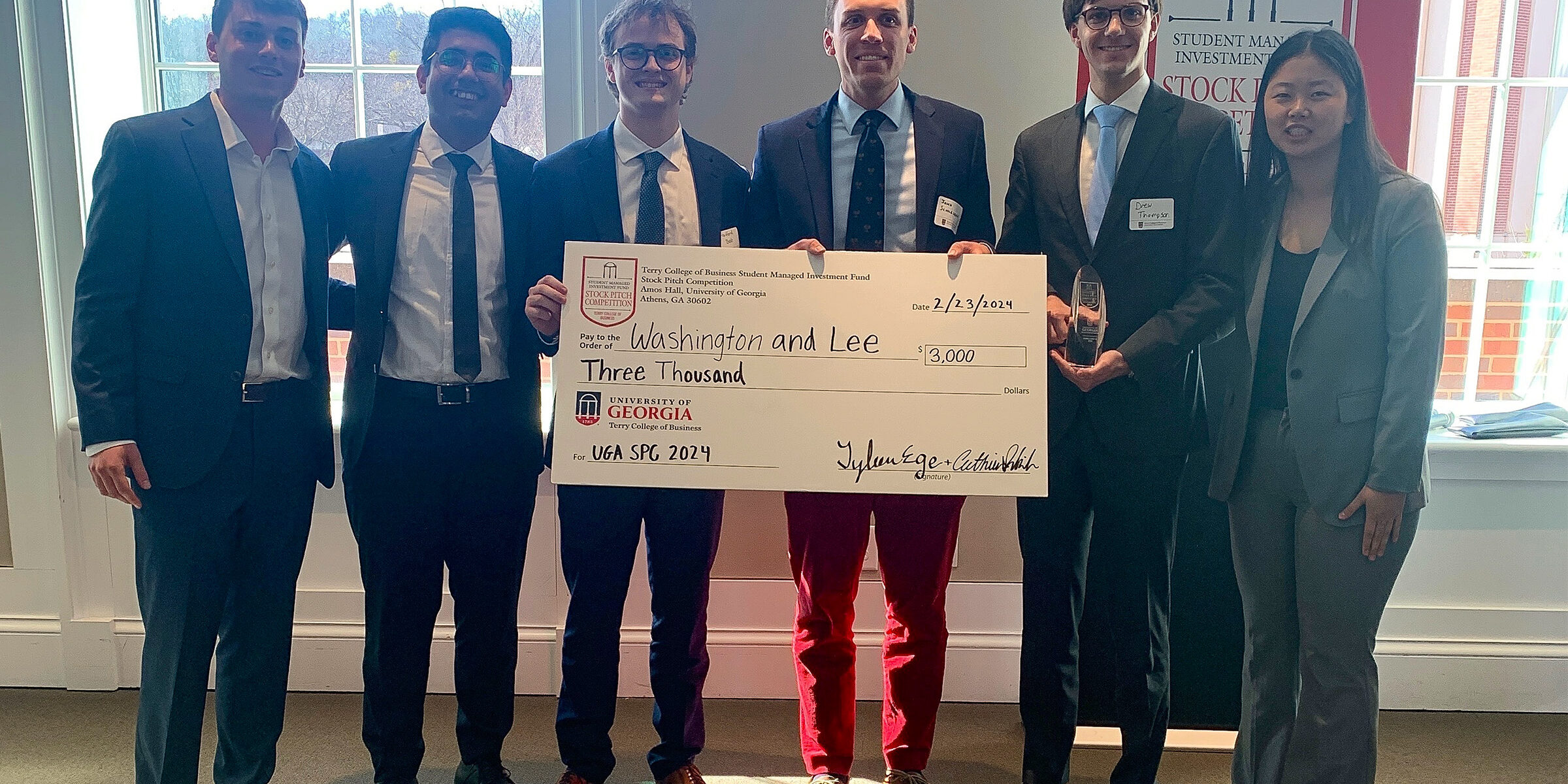 Group of people posing with a check