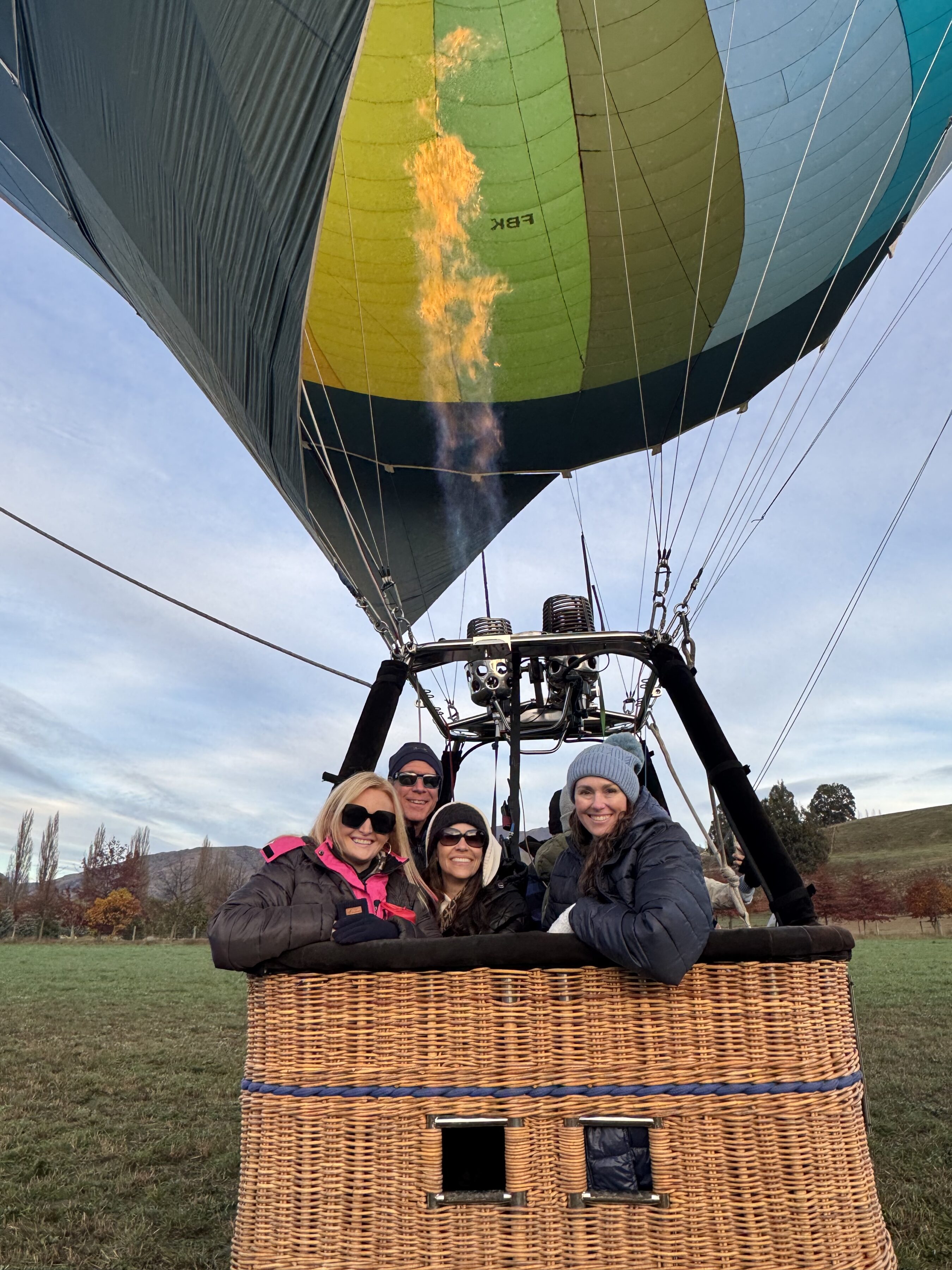 Four Terry College MBA students pose for a photo while standing a hot air balloon before takeoff.