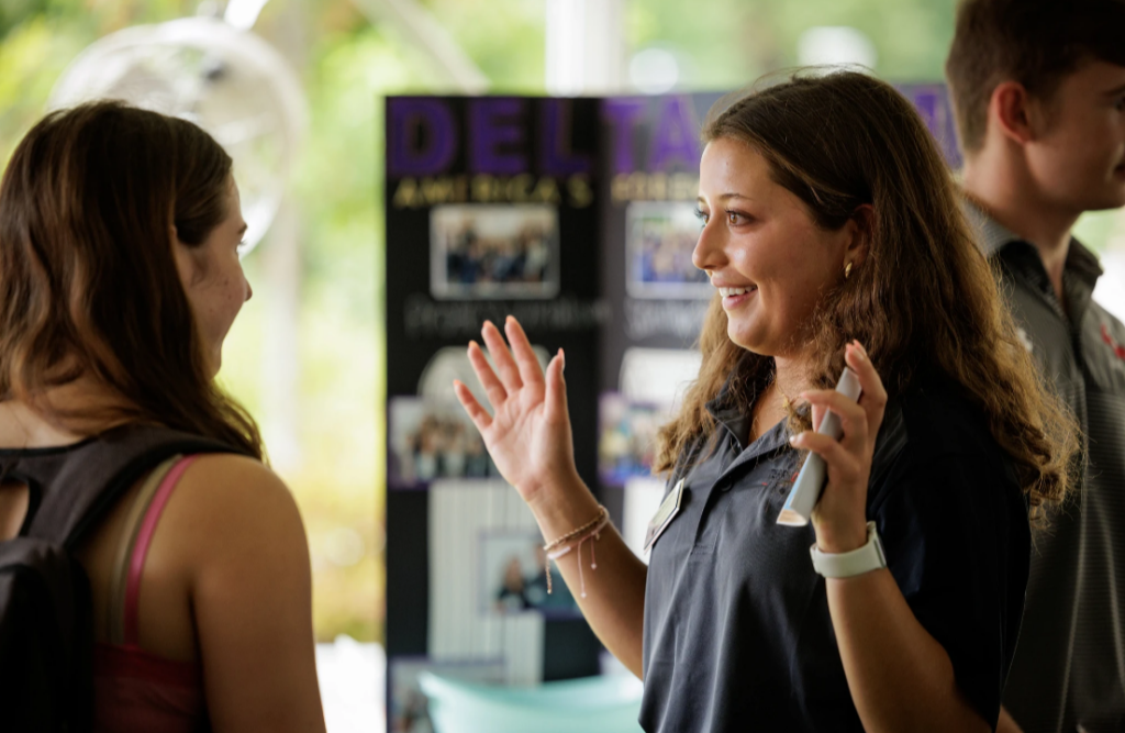 EY Fellow talking with student at Back To Business