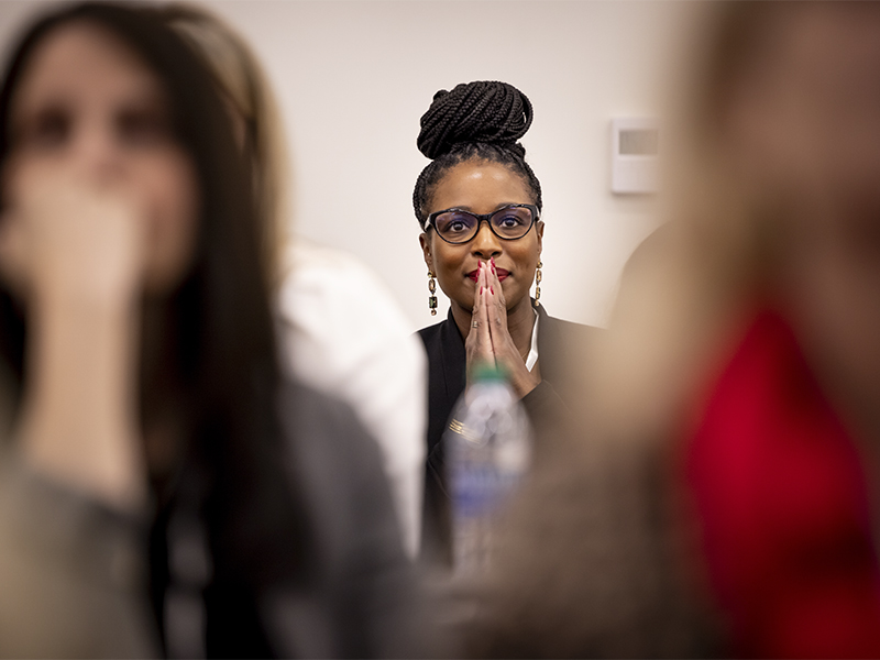 A woman focuses on a speaker out of frame