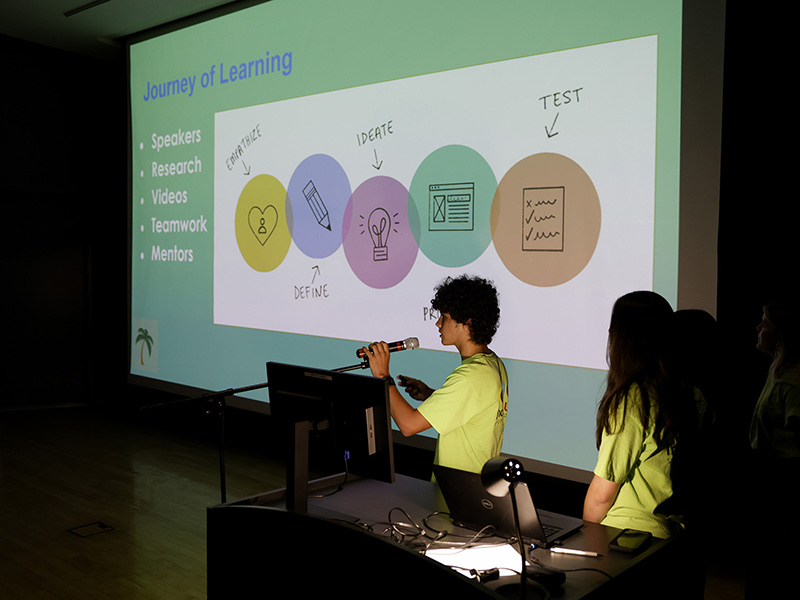 Students stand in front of a power point at Clarke Central