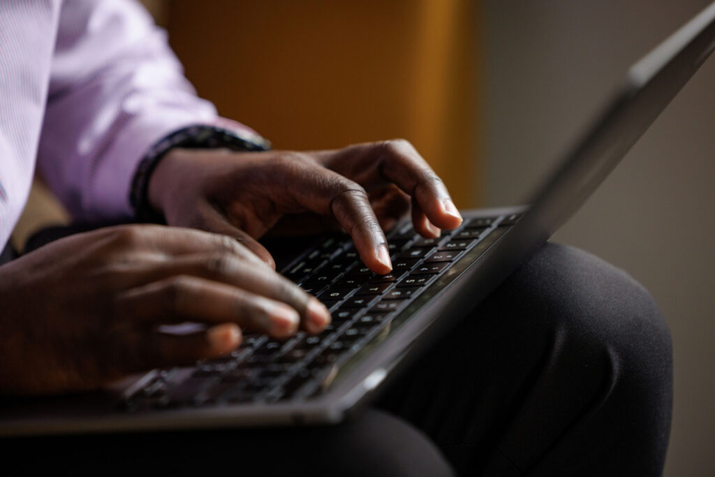 close up of hands typing on laptop