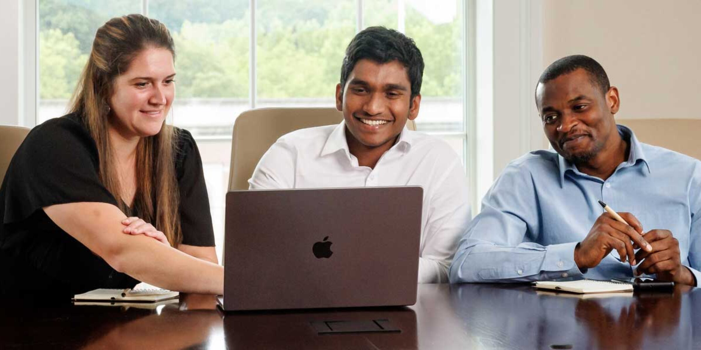 A female and two male Master of Accountancy students work together on an assignment with a laptop in front of them.