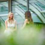 two females conversing on bench