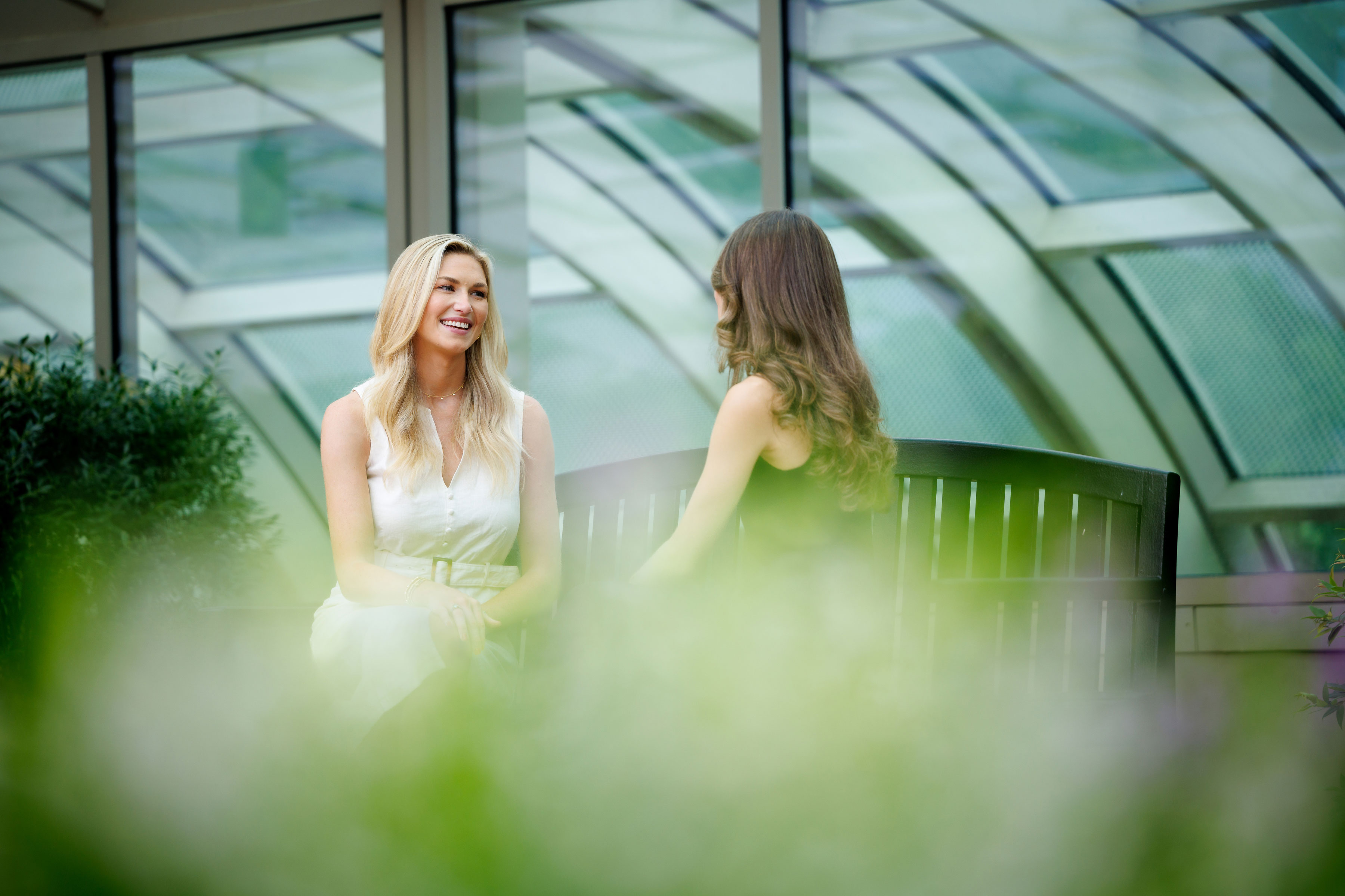 two females conversing on bench