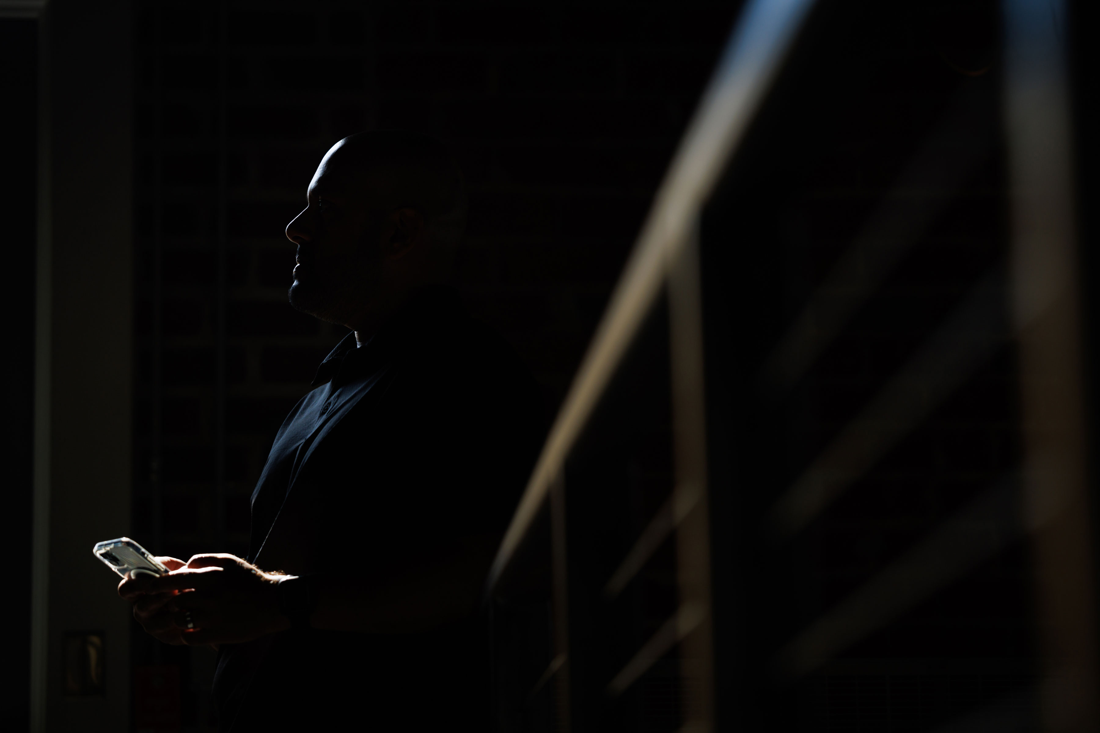 silhouette of male student holding phone