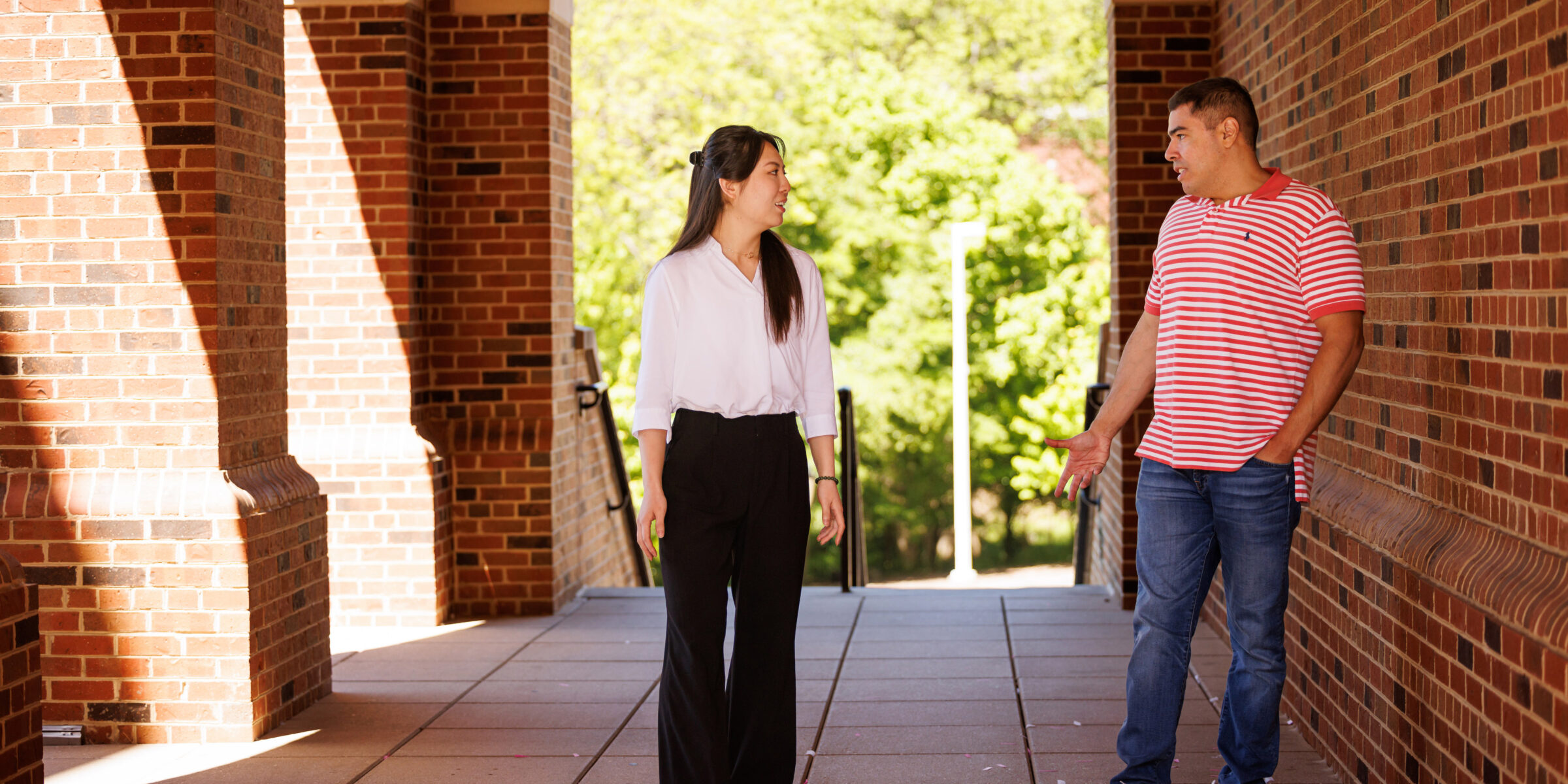 faculty member talking with PhD student in corridor