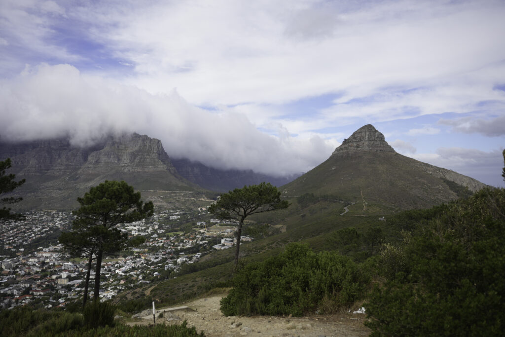 Mountains tower over a South African city with clouds forming around them.