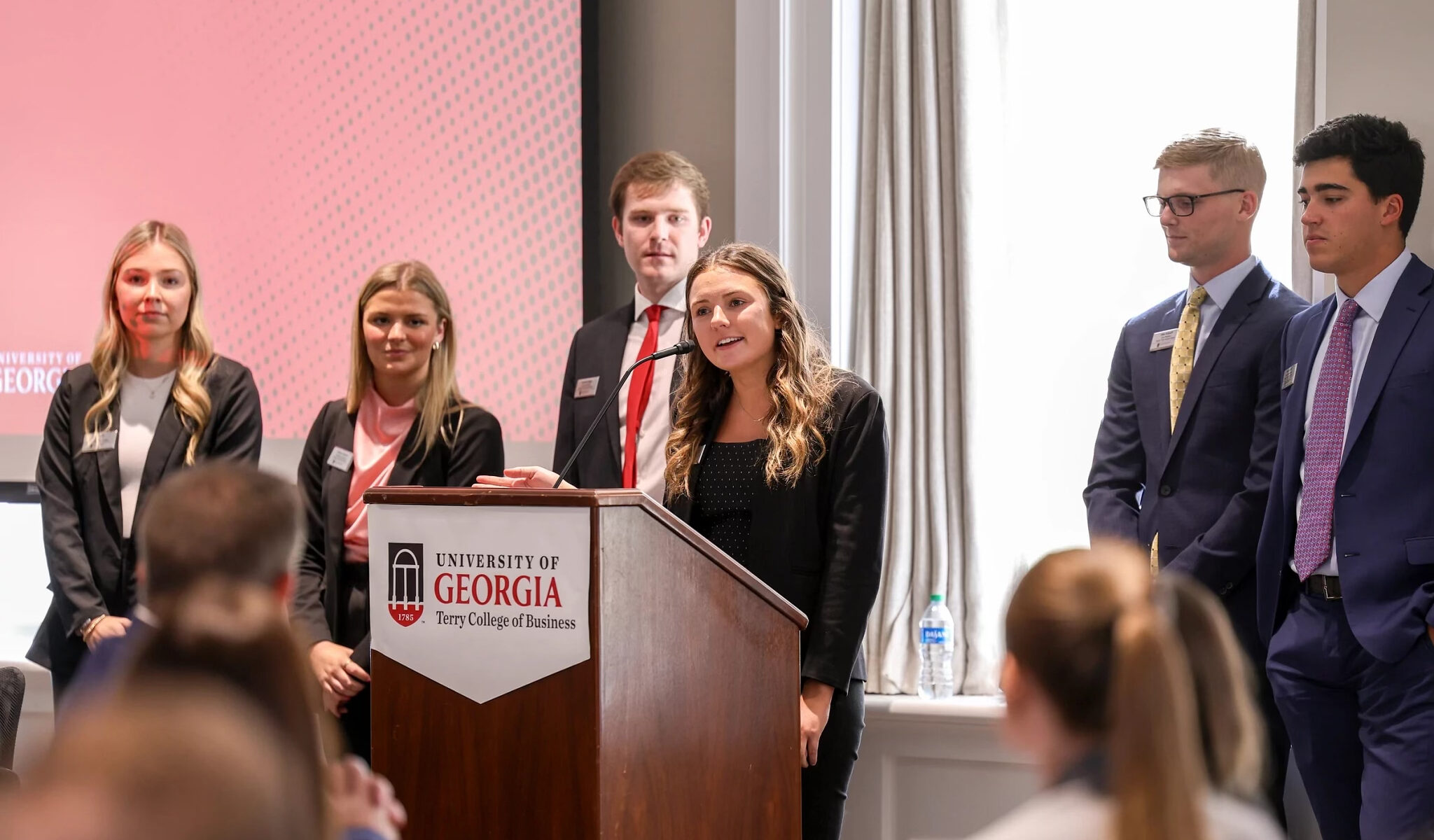 A group of people standing confidently behind a podium, addressing an audience with determination.