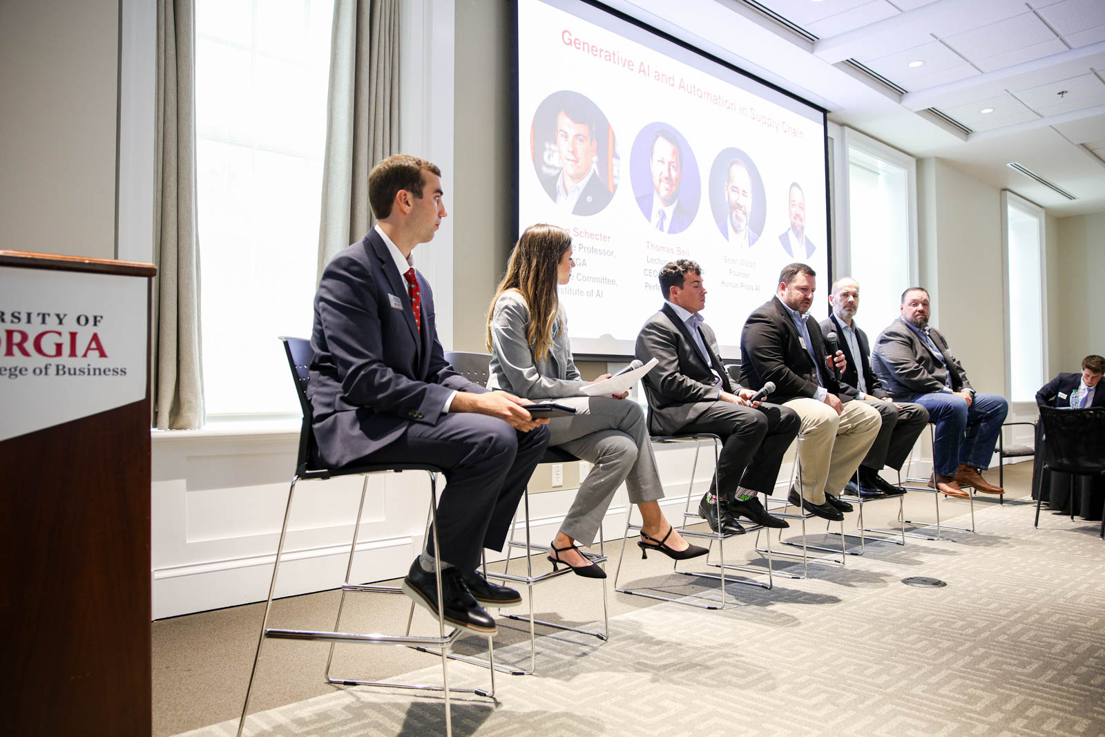 SCAB members sit down in front of presentation screen, looking out to crowd