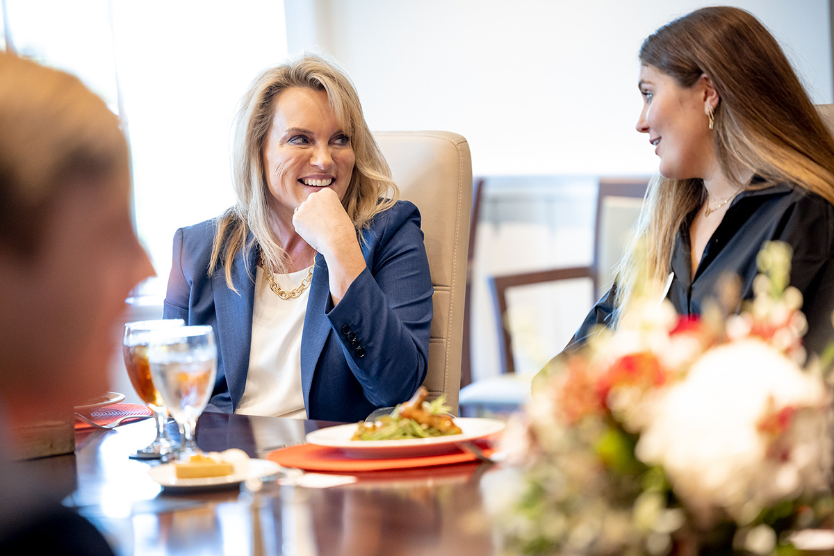 Julie Schertell talks with a student over lunch