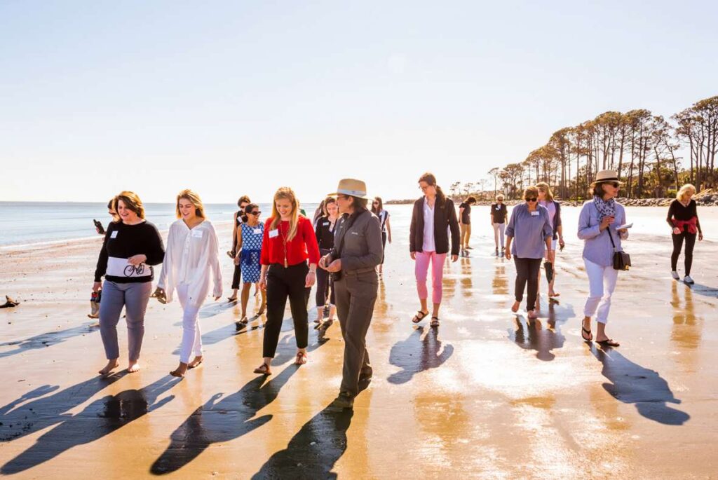 Sea Island Scholars attendees walk together on the beach.