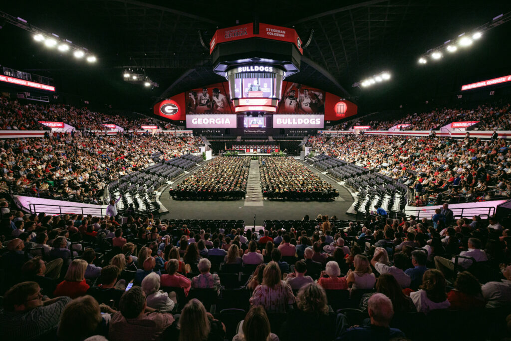 wide angle shot of graduates on the floor of Stegeman Coliseum