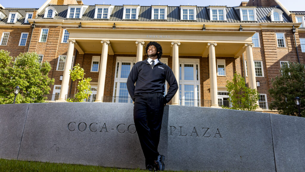 Trey Wilson poses against the Coca-Cola Plaza fountain with Amos Hall in the background