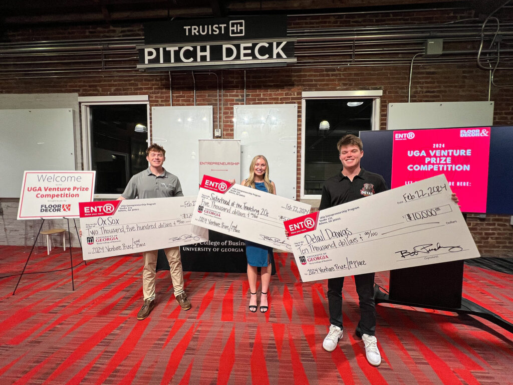 From left, Matt Tesvich, Kelsie Pearson and Jack TerHaar, stand with giant novelty prize checks in Studio 225