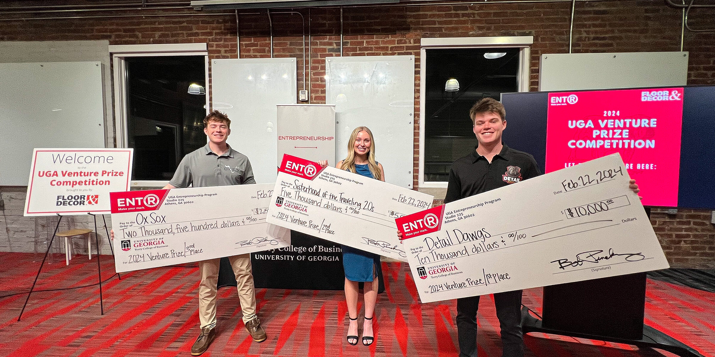 From left, Matt Tesvich, Kelsie Pearson and Jack TerHaar, stand with giant novelty prize checks in Studio 225