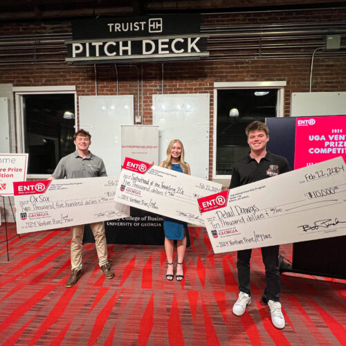 From left, Matt Tesvich, Kelsie Pearson and Jack TerHaar, stand with giant novelty prize checks in Studio 225