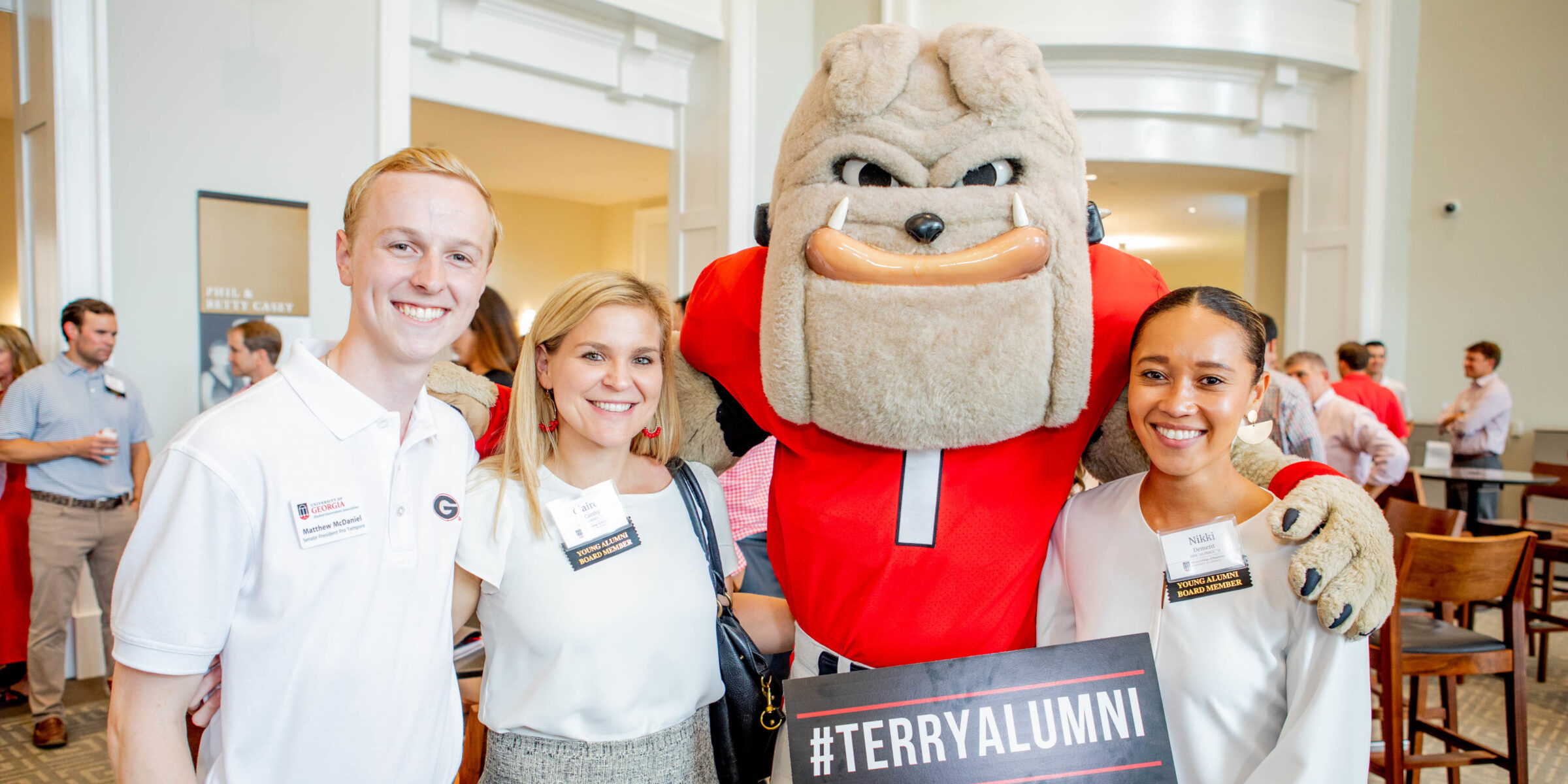 three alumni posing with Hairy Dawg